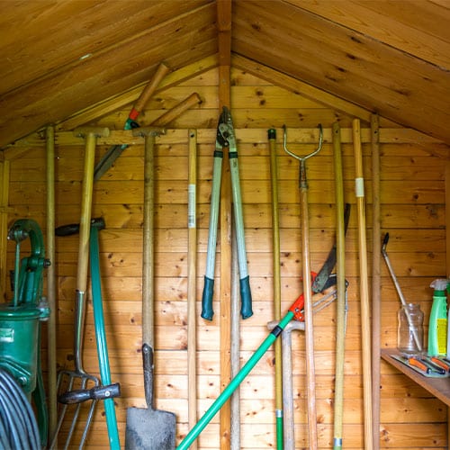 Organized tools and utility equipment in shed. 